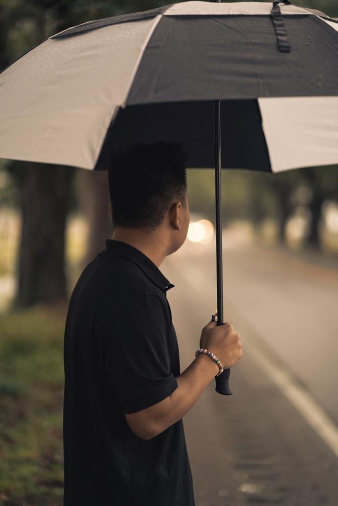 A man holding an umbrella, looking away