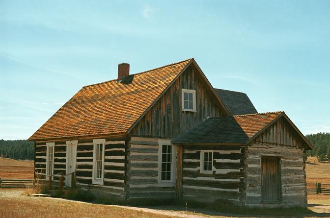 An old wooden building in a grassy field